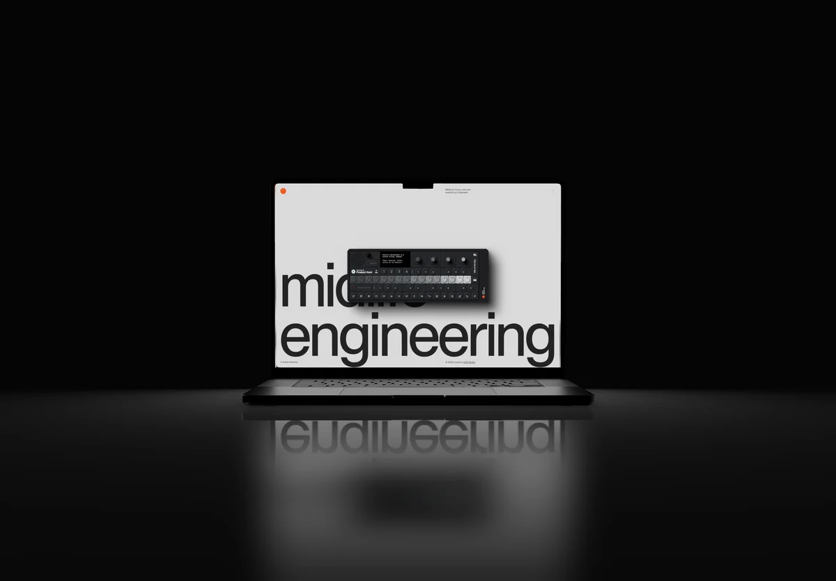 A laptop on a dark reflective floor, lit from behind, its screen reading mid engineering.