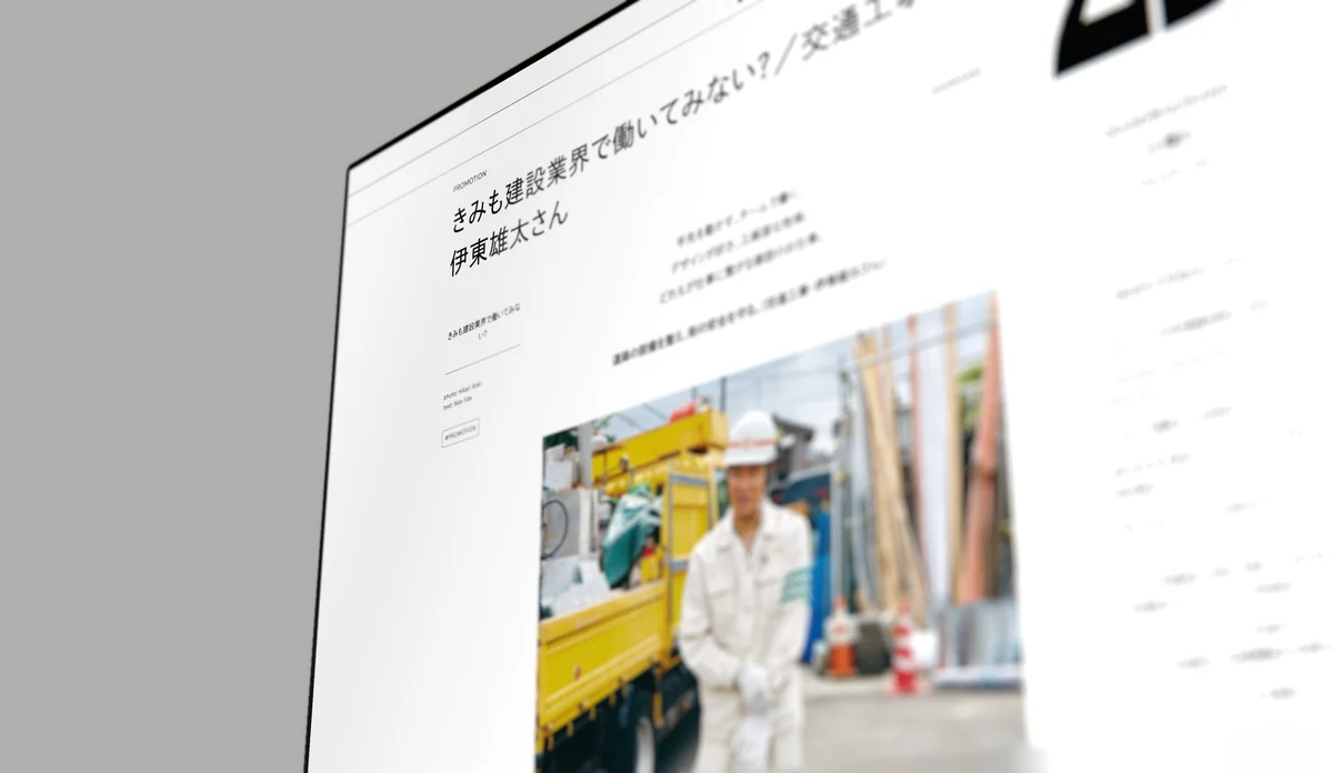 A monitor screen seen close at a steep angle, a Japanese article with a photograph of a builder on it.
