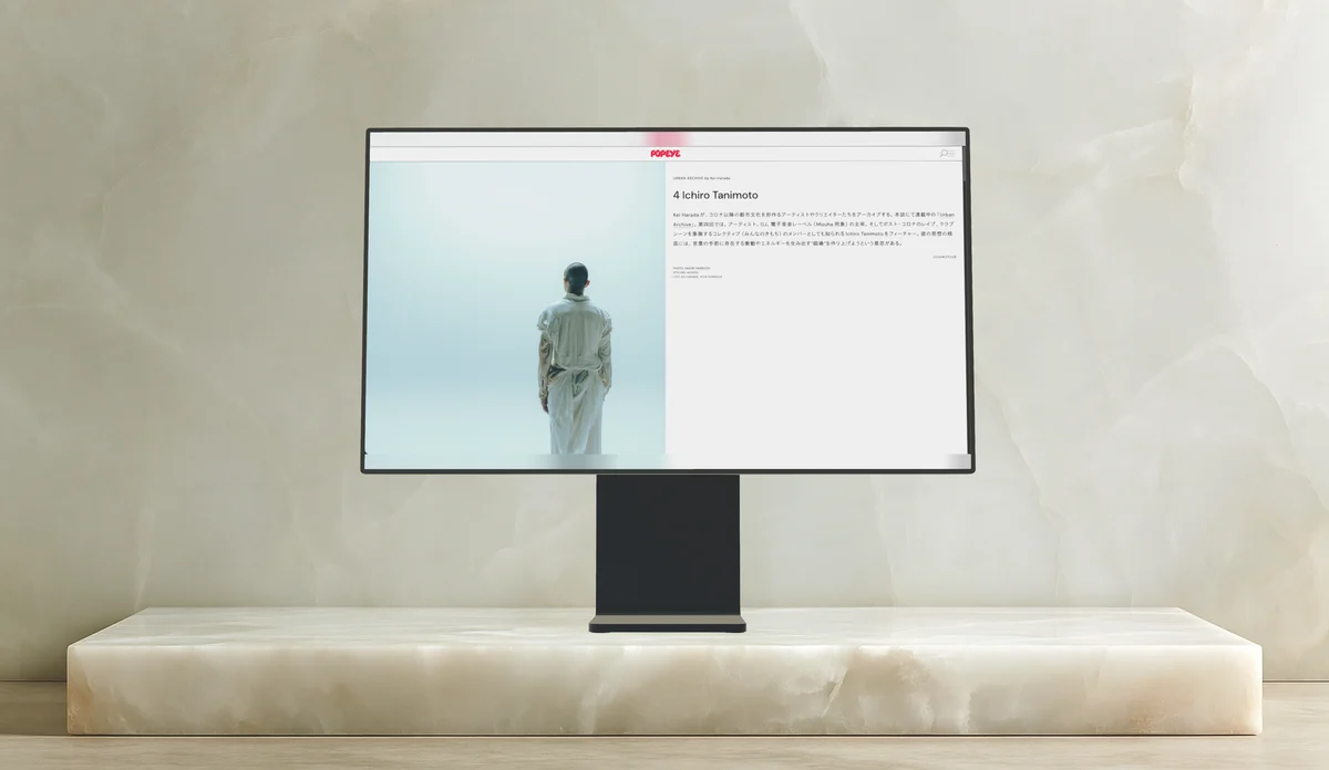 A monitor on a stand on an onyx plinth against a marble wall.