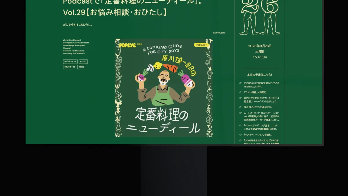 A monitor on a stand in darkness, a green Japanese magazine page on its screen.